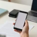 Telefon kamerasıyla masa üzerindeki belgeyi tarayarak PDF oluşturan kişi